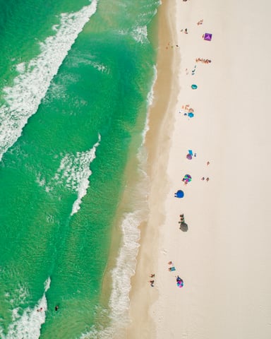 Aerial view of emerald green water and white sand beach