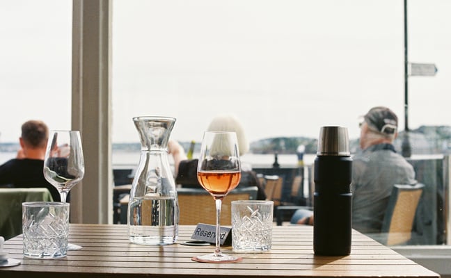 Rosé wine glass on a table at a waterfront restaurant