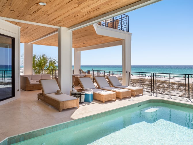 Beachfront deck with pool, lounge chairs, wooden ceiling, and ocean view